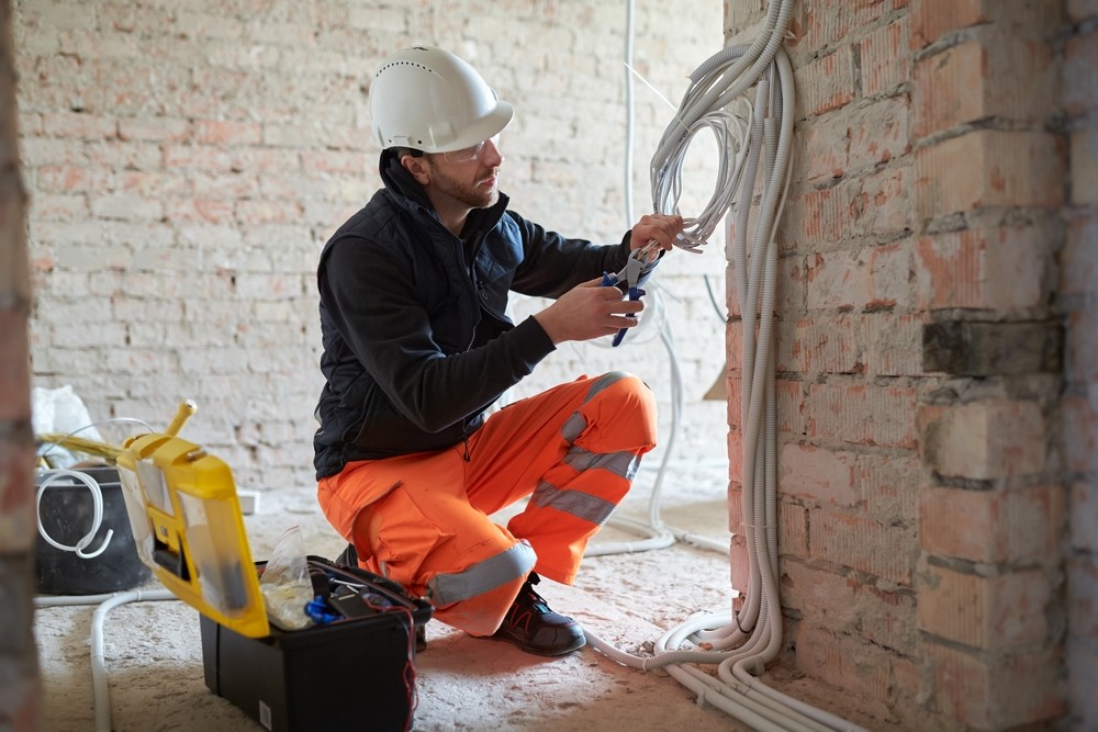 Electrician installing cables at a building project