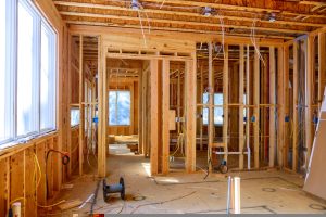 worker,installs,electrical,wires,,insulation,,and,ceiling,light,before,plasterboard in Chelmsford workplace